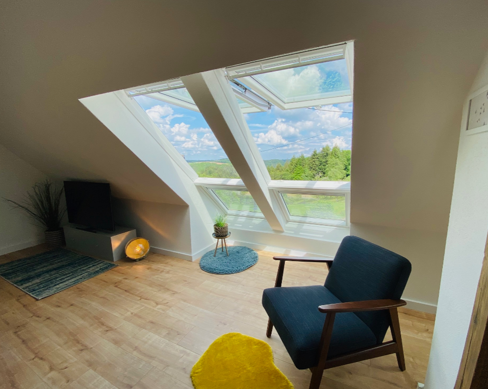Wohnraum im Dachgeschoss mit großen VELUX Dachfenstern