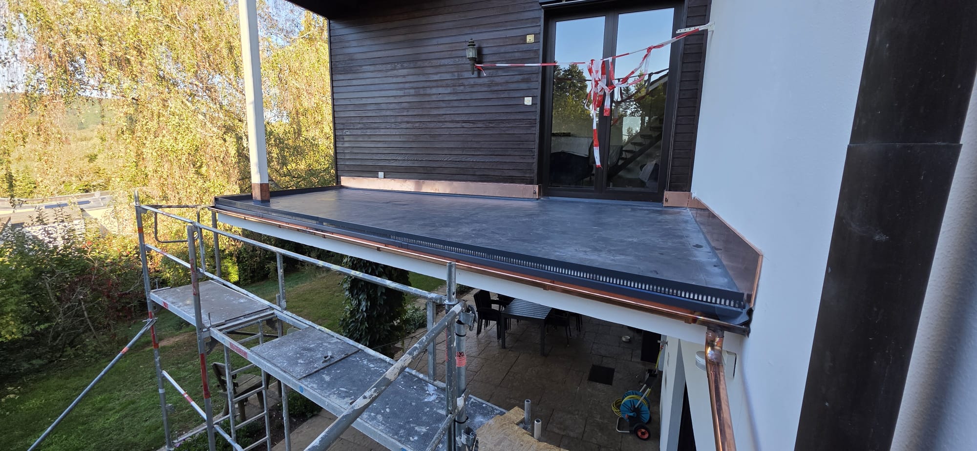 Neu abgedichteter Balkon mit Wandanschlüssen, Rinne und Fallrohr aus Kupfer