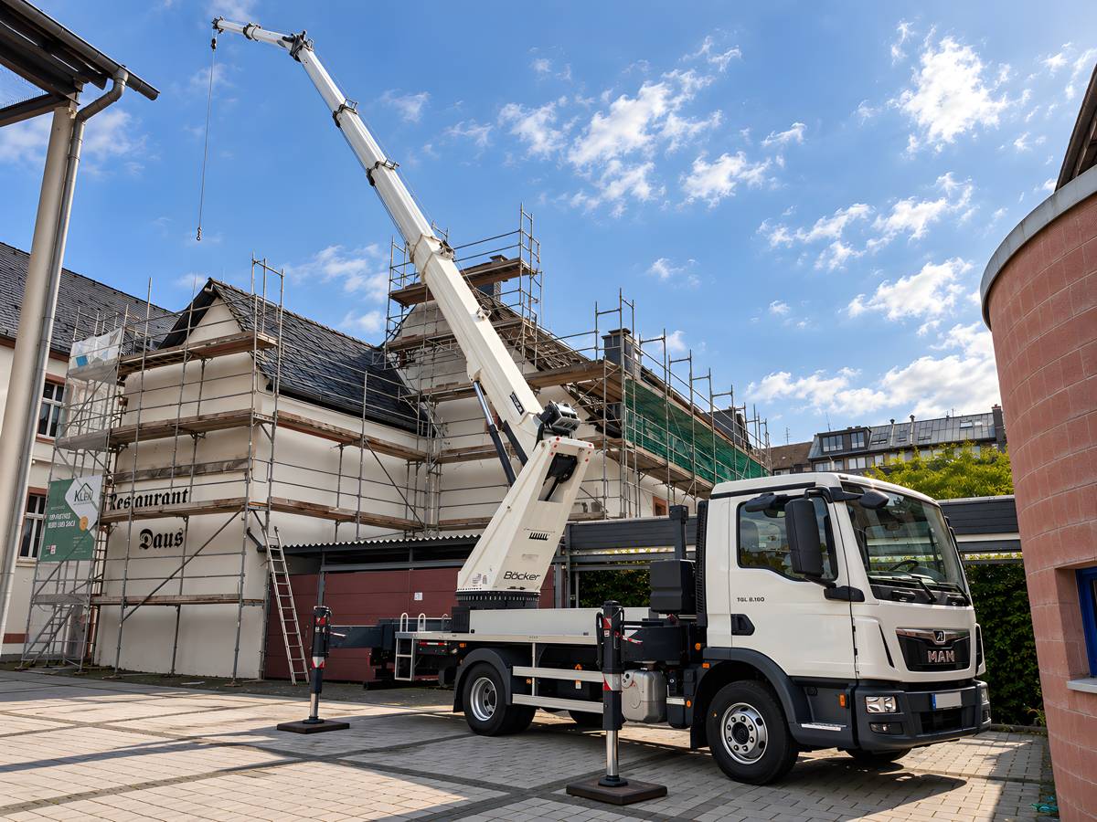 Böcker Autokran AK 37 der Dachdecker Klein GmbH im Einsatz an einem eingerüsteten Gebäude